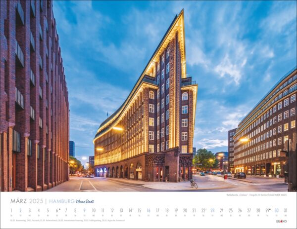 Ein Kalenderbild mit dem beleuchteten Chilehaus, einem berühmten eckigen Backsteingebäude in Hamburg – Meine Stadt 2025 in der Dämmerung. Der leuchtende Himmel kontrastiert mit den warmen Lichtern. Die Straßen sind ruhig, nur wenige Menschen sind unterwegs.