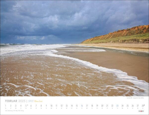 Eine Kalenderseite von Sylt – Meine Insel 2025 mit einem malerischen Strand auf der Insel Sylt. Meereswellen berühren ein Sandufer mit einem üppigen grünen Hügel unter einem dramatischen Wolkenhimmel. Tage des Monats