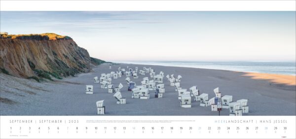 Ein Panoramablick auf einen Strand im Morgengrauen mit zahlreichen weißen Strandstühlen mit blauen Akzenten, die willkürlich im Sand angeordnet sind, in der Nähe einer hohen Sandklippe auf der linken Seite. Oben ist eine Kalenderüberschrift für Meerlandschaft 2025.