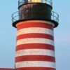 Ein LongEiland - Kalender 2025 Dezember-Poster mit dem West Quoddy Head Lighthouse in Maine, USA. Der Leuchtturm ist rot-weiß gestreift und mit einem beleuchteten Leuchtfeuer ausgestattet.