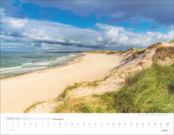 Eine Kalenderseite für DÄNEMARK - richtig hyggelig 2025 mit einer unberührten Strandszene in Dänemark mit einer Düne, die mit üppigem grünem Gras bedeckt ist, einem breiten Sandstrand und einem ruhigen Meer, unter einem teilweise