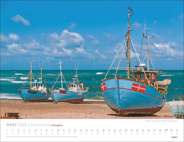 Eine Kalenderseite für März 2025 mit einem Foto von zwei blauen und roten Fischerbooten an einem Sandstrand mit dem aufgewühlten blauen Meer und einem klaren Himmel im Hintergrund, das an „DÄNEMARK – richtig hyggelig 2025“ erinnert.