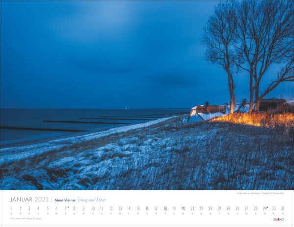 Ein Mein kleines Haus am Meer 2025-Kalender über einer nächtlichen Strandszene. Der Strand zeigt leuchtende orangefarbene Lichter in der Nähe des Grases, ein ruhiges Meer, entfernte Buhnen und einen dunkelblauen Himmel. Ein schwaches Licht ist