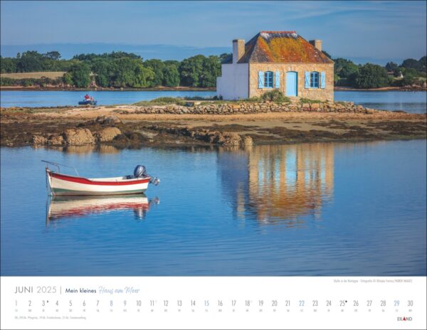 Eine ruhige Landschaft, die Mein kleines Haus am Meer 2025 mit einem blauen Dach auf einer kleinen, üppigen Insel zeigt, die sich im ruhigen Meer spiegelt. Ein weiß-rotes Boot schwimmt in der Nähe. Das Bild ist als Juni gerahmt