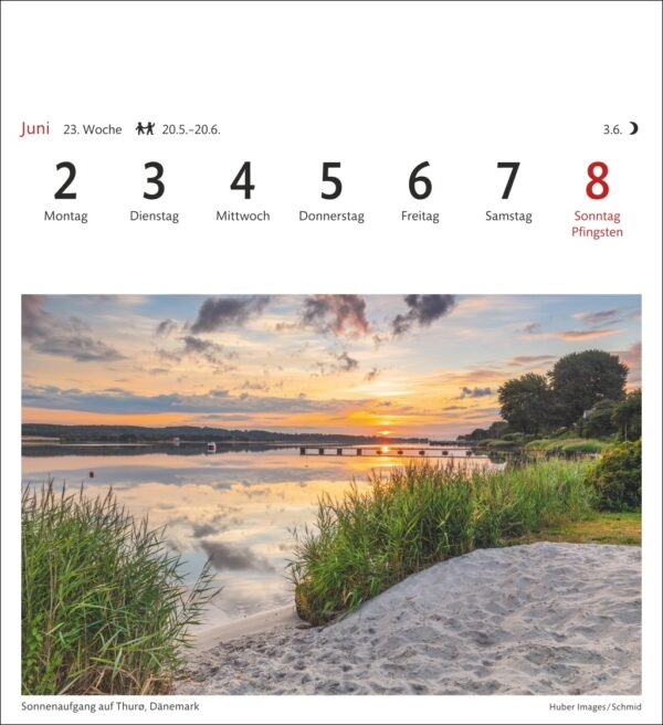 Ein heiterer Morgen in Thuro, Dänemark, mit einem leuchtenden Himmel und Spiegelungen über einem ruhigen See, mit einer Brücke in der Ferne und einem sandigen Vordergrund, eingerahmt in einen Kalender mit dem 8. Juni, der als Sonntag und Feiertag (Pfingsten) beschriftet ist.