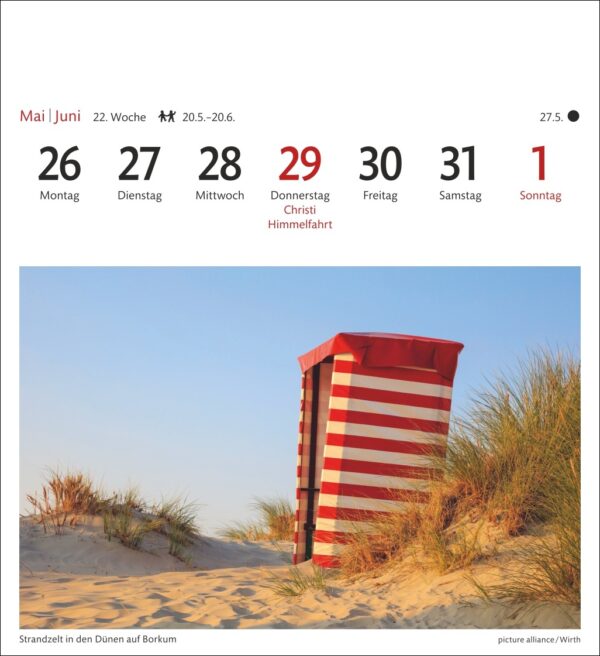 Ein rot-weiß gestreifter Strandkorb auf Sanddünen mit Gras unter einem klaren blauen Himmel. Das Bild zeigt auch einen Kalender für die letzte Maiwoche, wobei der 29. als „Christi Himmelfahrt“ hervorgehoben ist.