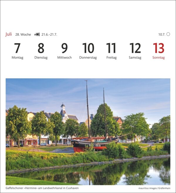 Eine Kalenderseite für die Woche vom 7. bis 13. Juli mit einem Landschaftsfoto des Schiffs Hermine, das im Landwehrkanal in Cuxhaven vor Anker liegt, flankiert von grünen Bäumen und historischen Gebäuden unter einem klaren Himmel.